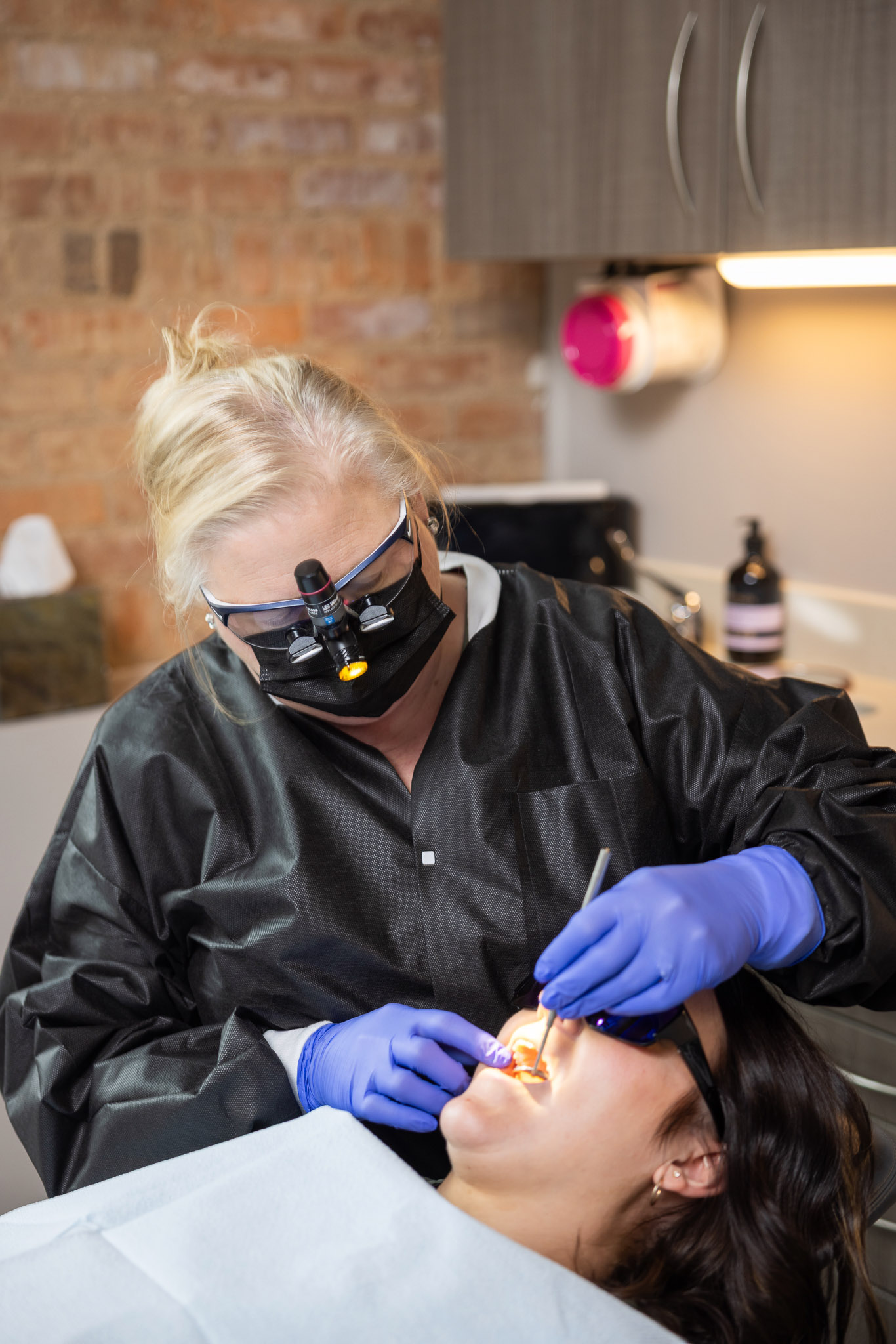 A clinician using a dental light while treating a patient in the operatory at Ireland Restorative Dentistry