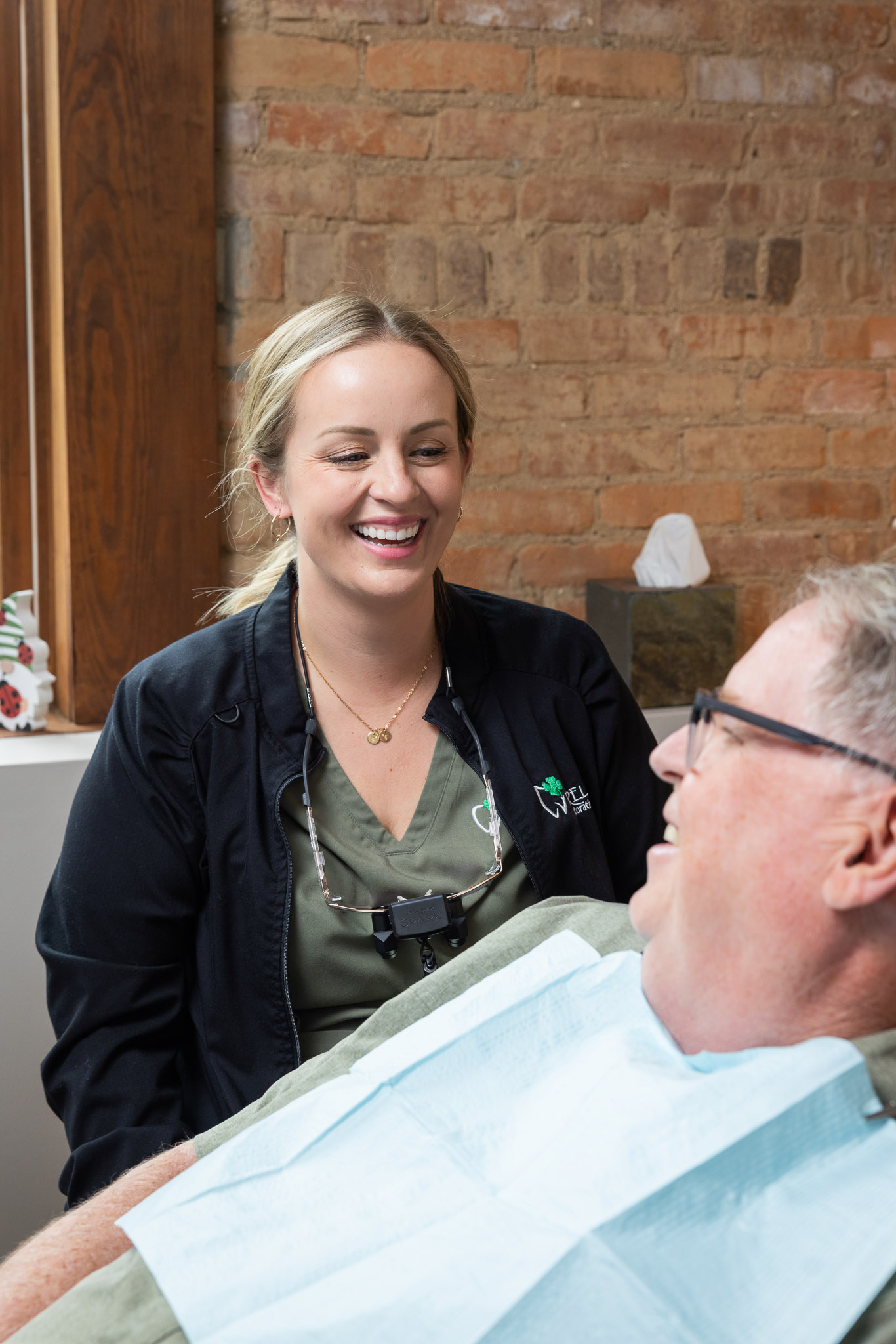A smiling clinician at Ireland Restorative Dentistry warmly engaging with a patient before their procedure
