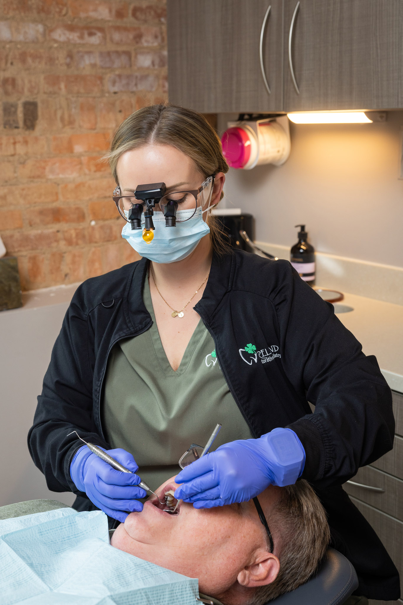 Dental treatment room at Ireland Restorative Dentistry, with a clinician in loupes and mask treating a patient