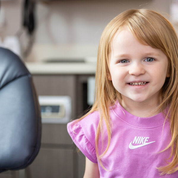 A young patient smiling happily in the dental chair at Ireland Restorative Dentistry